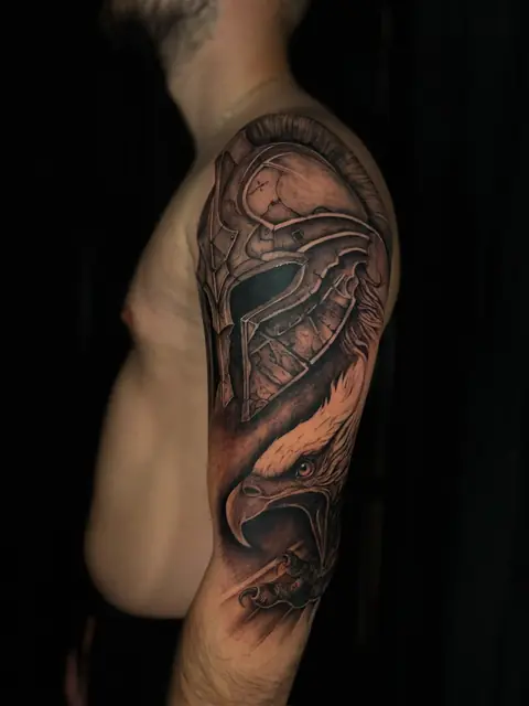 Spartaner-Helm und Adlerkopf als Realism-Sleeve in Black & Grey auf dem Oberarm