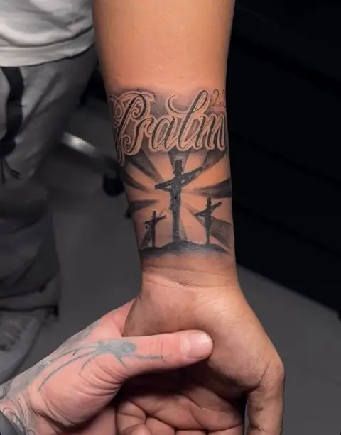 Schriftzug „Psalm 23“ mit realistischer Kreuzigungsszene auf dem Unterarm